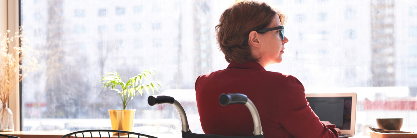 Thoughtful Woman in Wheelchair Looking out Window at City