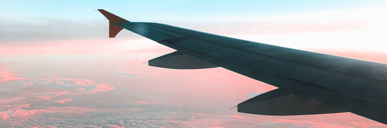 Airplane Wing Flying Over a Sunset.