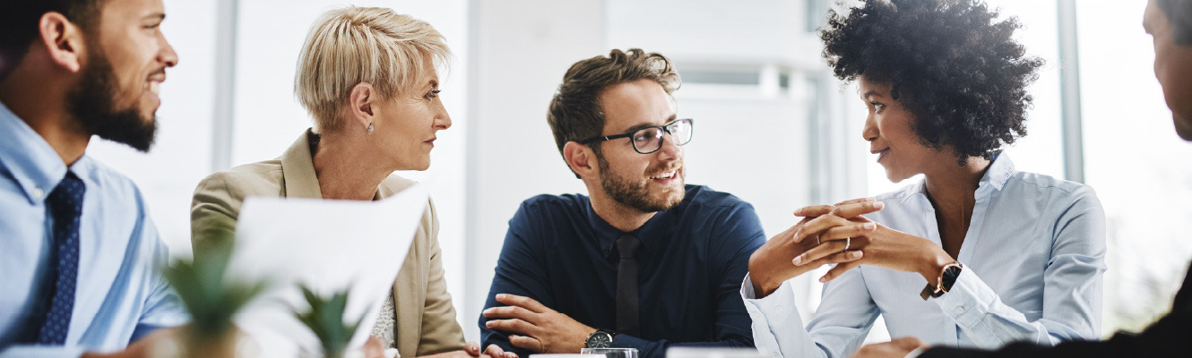 A diverse group of coworkers sitting and talking in a meeting