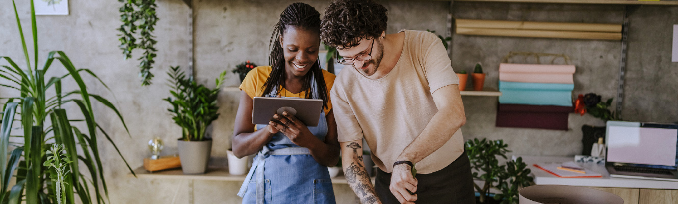 A man and woman looking at an iPad