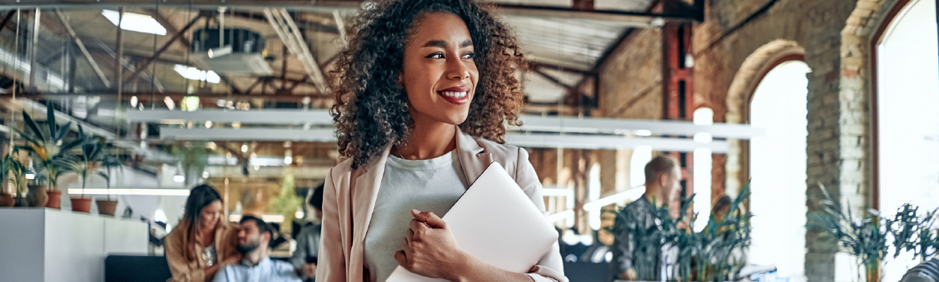 A young woman in business attire standing in an office