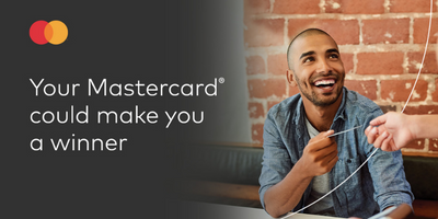 Guy exchanging Mastercard card with person while smiling. 