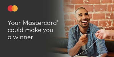 Guy exchanging Mastercard card with person while smiling.