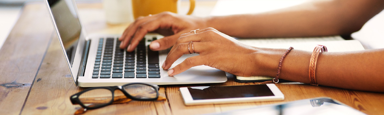 Close up of hands typing on a laptop keyboard