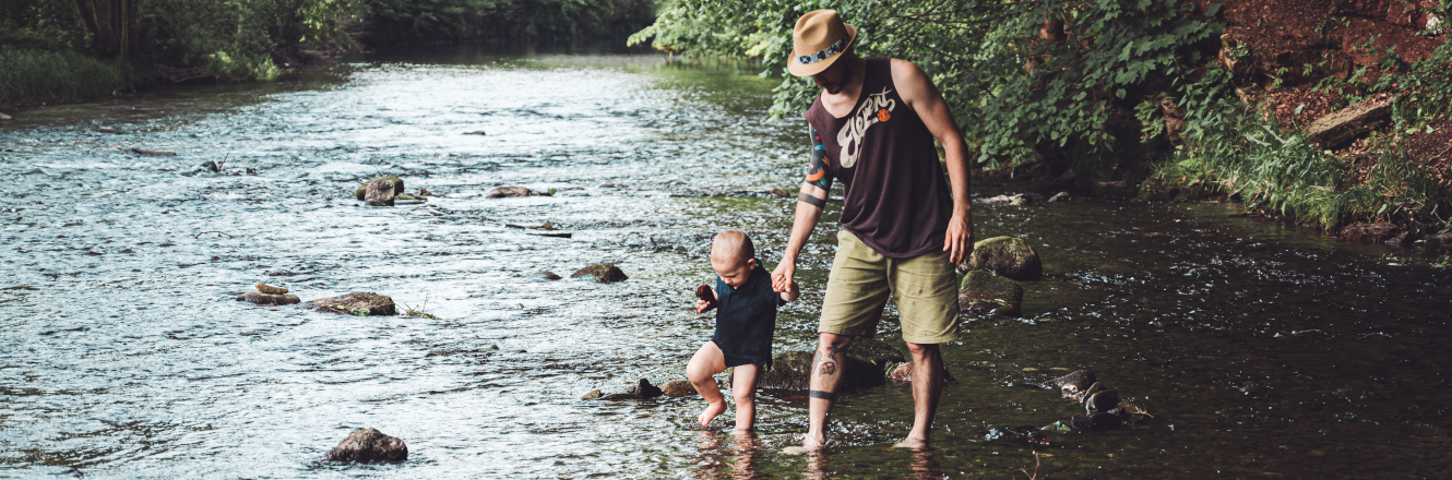 Father and Young Son Walking in a Shallow River