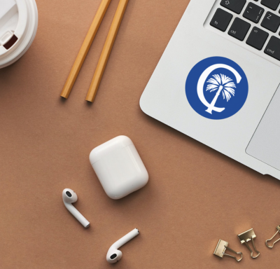 Laptop with CB logo. Headphones and Pencils on desk.