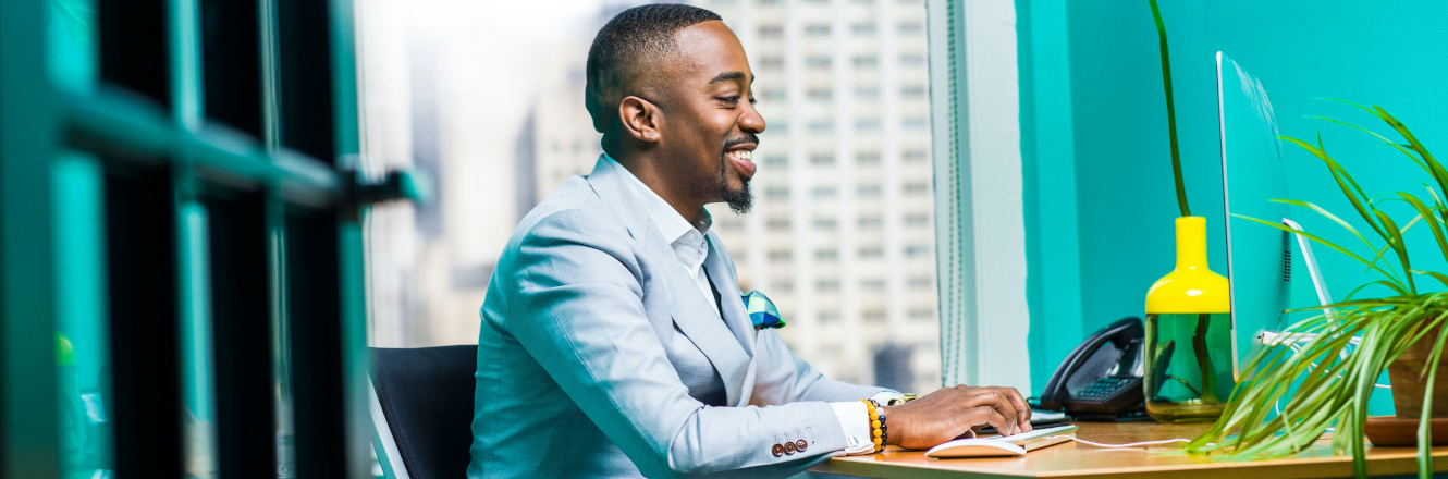 Smiling Man in Suit Looking at Screen