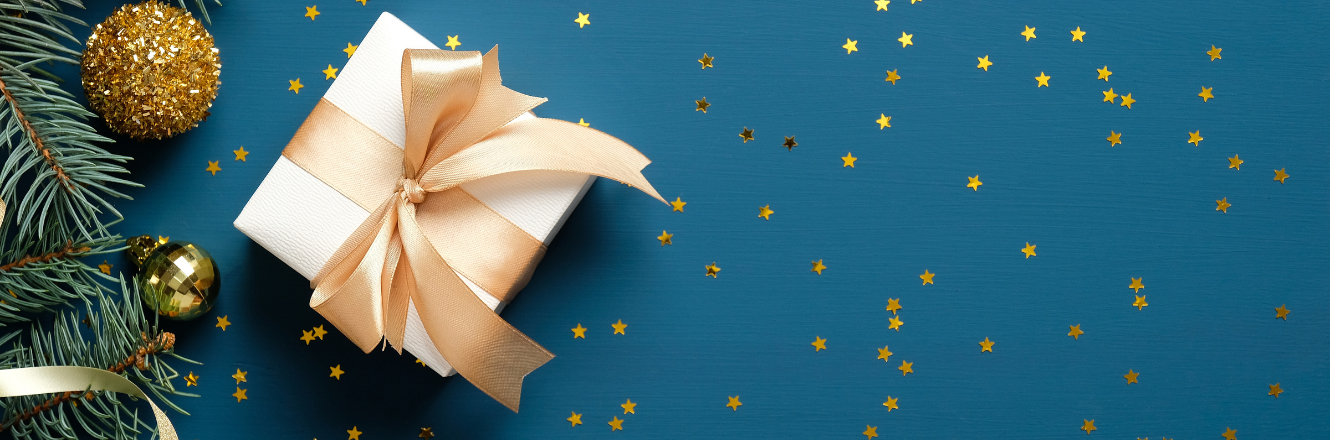 Christmas gift on a blue background with gold star confetti. 