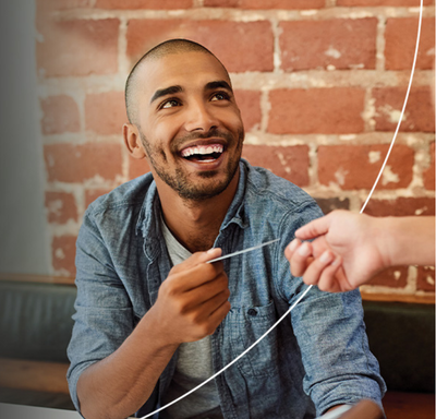 Smiling man exchanging Mastercard card with person.