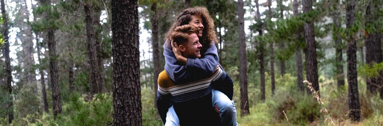 Banner of a people doing a piggyback ride in a green forest