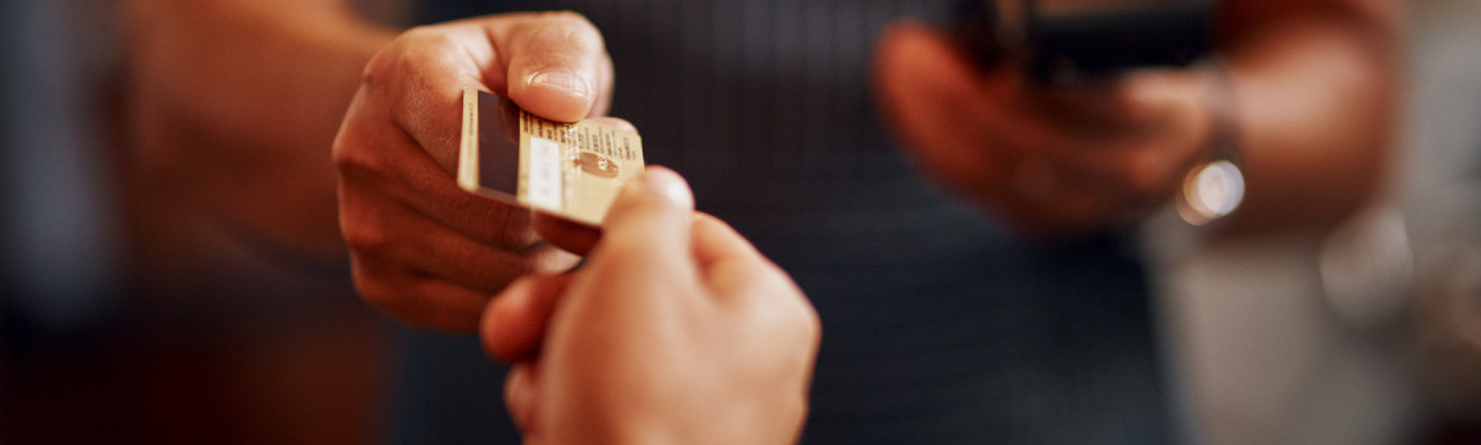 Close up of two hands exchanging a credit card